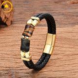 alt="Bracelet homme en cuir tressé noir avec pierres œil de tigre doré et œil de faucon bleu-gris, fermoir doré"
