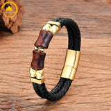 alt="Bracelet homme en cuir tressé noir avec pierre œil de taureau rouge et fermoir doré"
